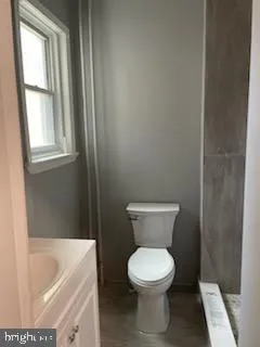 a bathroom with a toilet and white tub