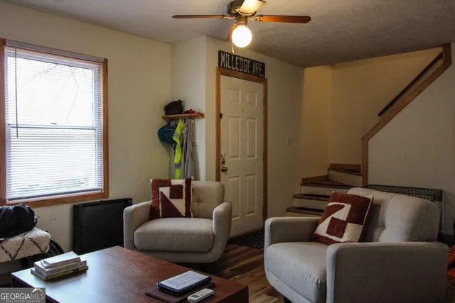 a kitchen with stainless steel appliances granite countertop a refrigerator a sink dishwasher a stove and a dining table with wooden floor