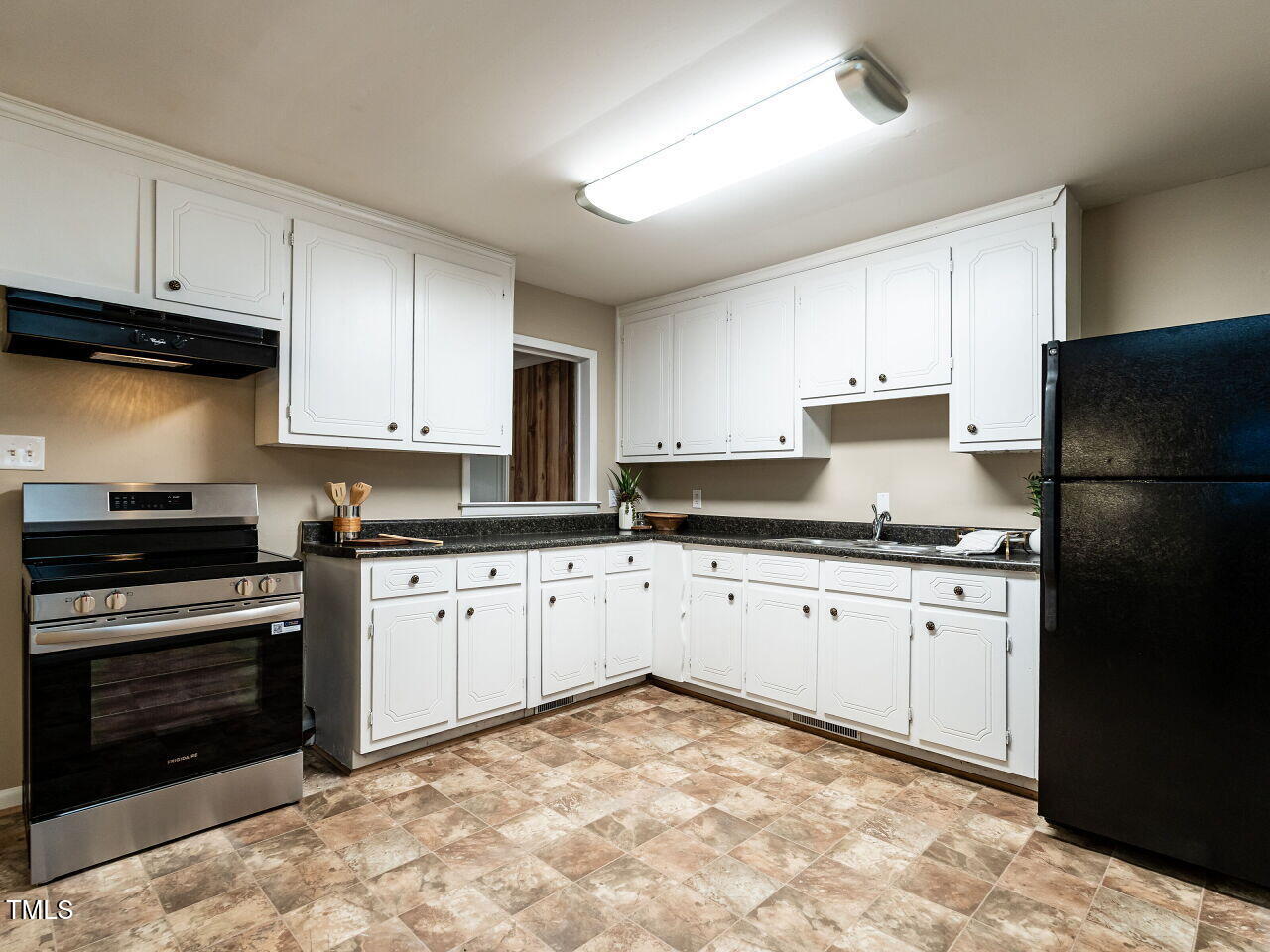 829 Greenwich Street Raleigh, NC 27610 - Photo 10 of 29 a kitchen with granite countertop a refrigerator stove top oven and sink