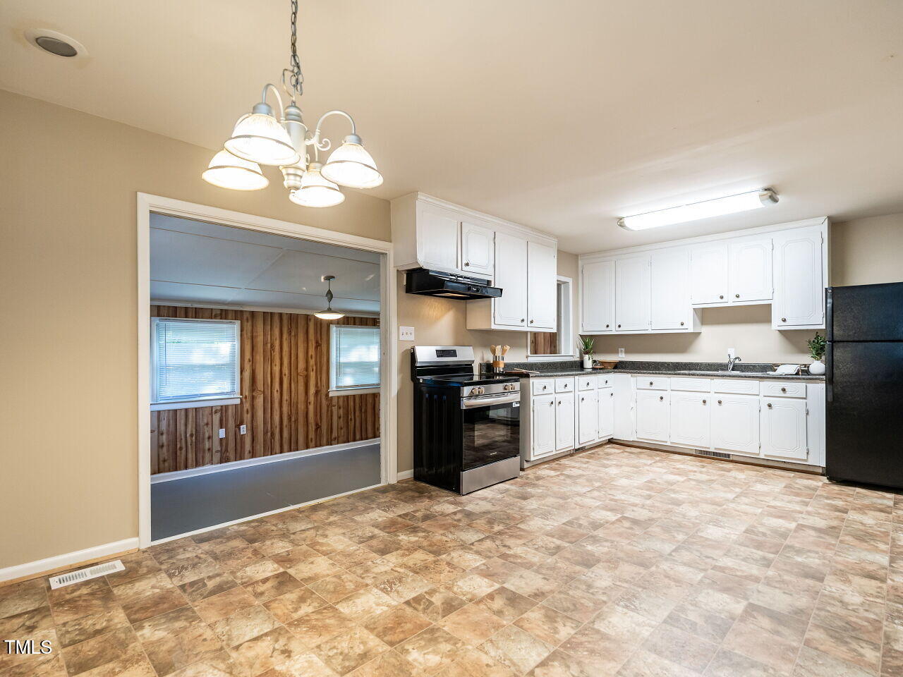 829 Greenwich Street Raleigh, NC 27610 - Photo 16 of 29 a large kitchen with kitchen island granite countertop stainless steel appliances cabinets a sink and a chandelier