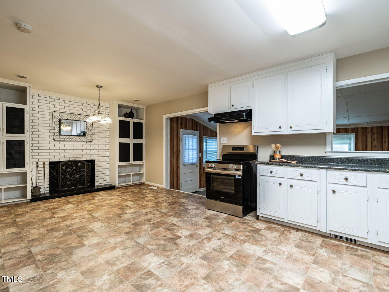 829 Greenwich Street Raleigh, NC 27610 - Photo 3 of 29 a kitchen with granite countertop a stove a sink and a refrigerator