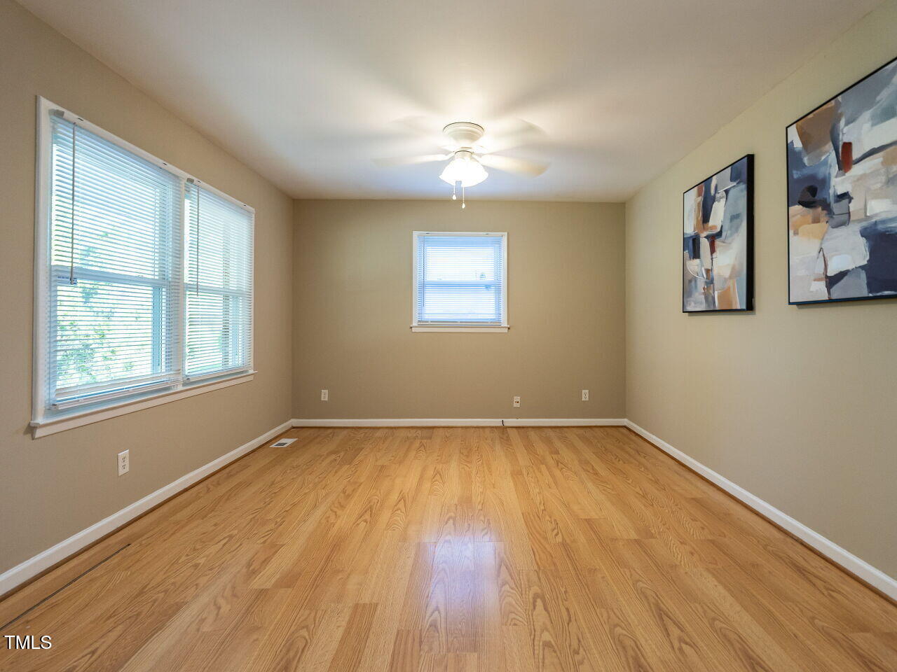 829 Greenwich Street Raleigh, NC 27610 - Photo 4 of 29 a view of an empty room with wooden floor and a window