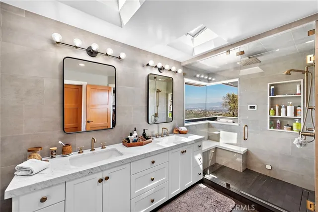 a bathroom with a double vanity sink mirror and toilet