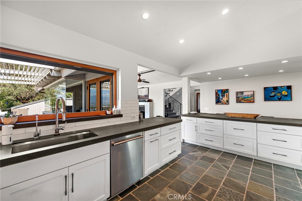 3085 Nestall Road Laguna Beach, CA 92651 - Photo 8 of 33 a large white kitchen with granite countertop a sink and dishwasher a stove top oven with wooden floor