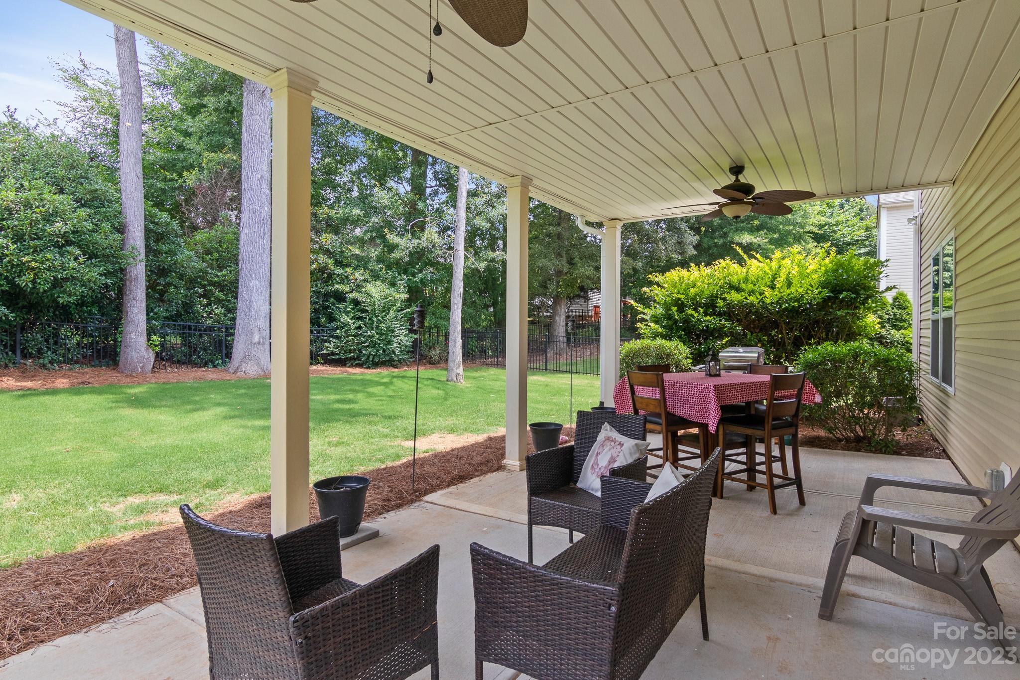 7228 Meyer Road Fort Mill, SC 29715 - Photo 43 of 45 a view of a patio with table and chairs potted plants and a palm tree