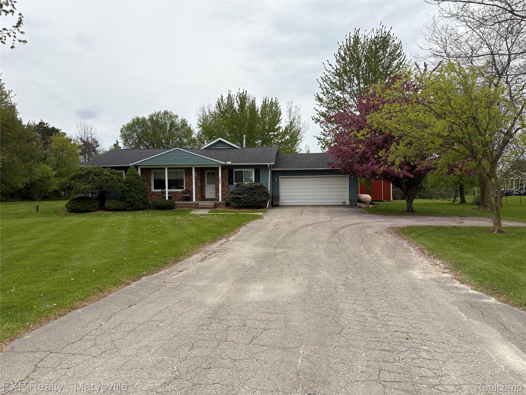 12265 Hough Road Memphis, MI 48041 - Photo 35 of 41 Ranch-style home featuring a porch, a front lawn, asphalt driveway, a garage, and brick siding