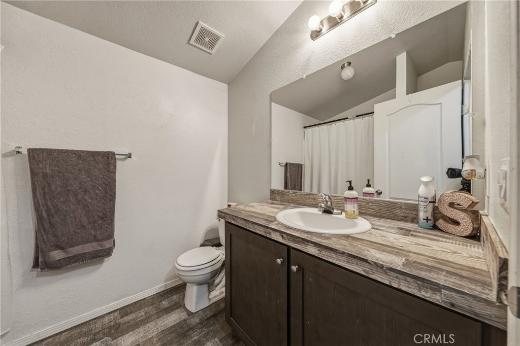6219 Roland Drive Lucerne, CA 95458 - Photo 16 of 29 a bathroom with a granite countertop sink a toilet and a mirror
