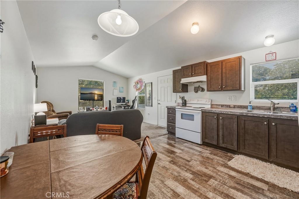 6219 Roland Drive Lucerne, CA 95458 - Photo 10 of 29 a kitchen with stainless steel appliances granite countertop a stove top oven a sink dishwasher a dining table and chairs with wooden floor