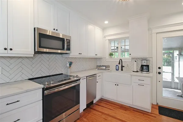 a kitchen with white cabinets stainless steel appliances and sink