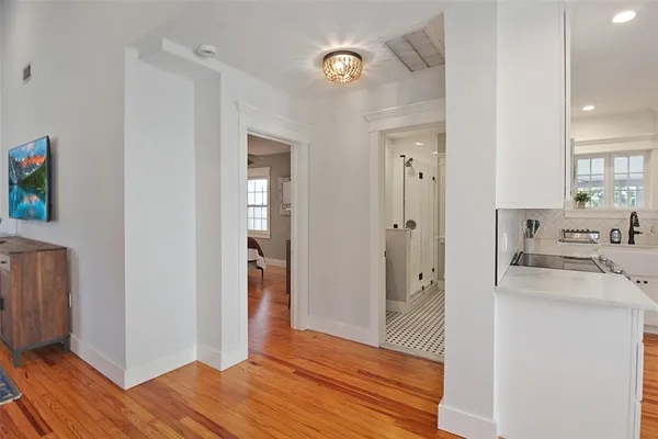a view of a kitchen from the hallway with wooden floor