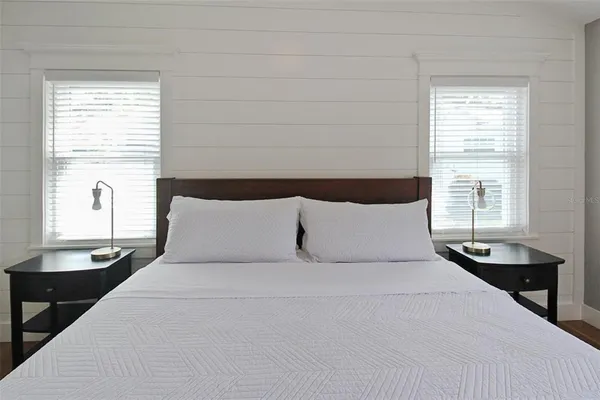 a large bed sitting in a bedroom next to a window