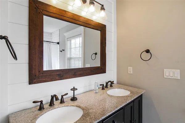 a bathroom with a granite countertop sink and a mirror