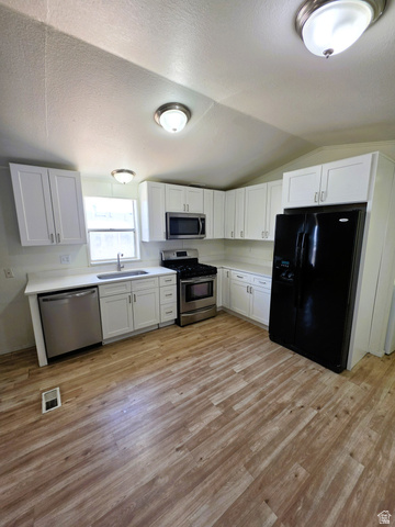 1604 180 East Tooele, UT 84074 - Photo 6 of 16 Kitchen featuring wood-finish flooring, white cabinetry, white quartz countertops, a stainless steel dishwasher, and a stainless steel range with an overhead microwave