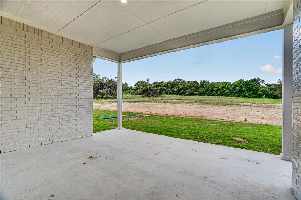 317 Skeen Peak Springtown, TX 76082 - Photo 28 of 31 Spacious covered patio with light-colored brick wall, concrete flooring, and recessed ceiling lighting