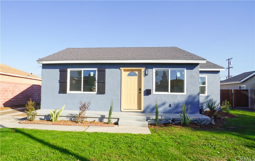 a backyard of a house with table and chairs potted plants and wooden fence