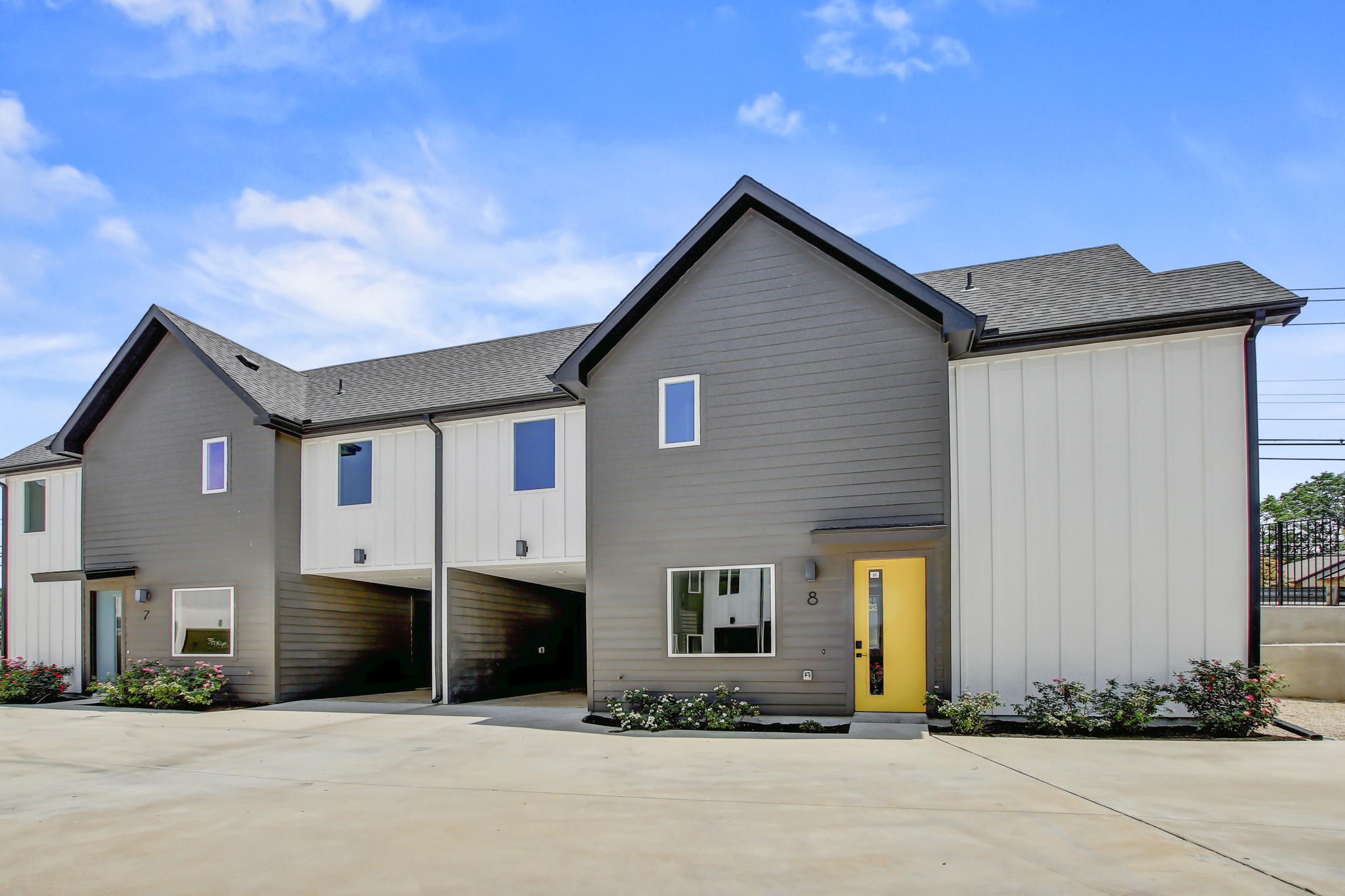 4127 East 12th Street, Unit 8 Austin, TX 78721 - Photo 31 of 32 View of front facade with a shingled roof, board and batten siding, and driveway