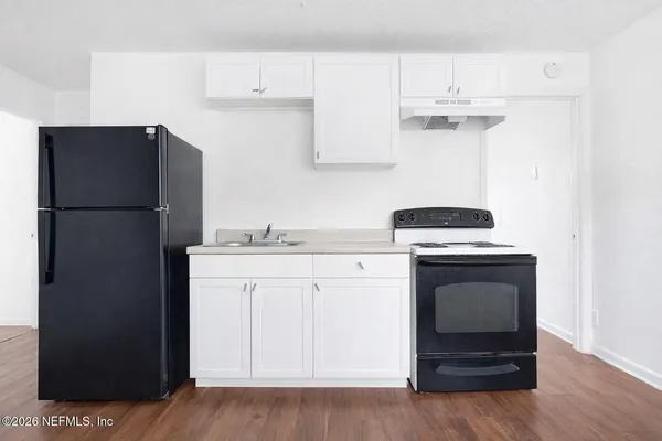 a kitchen with a refrigerator sink and cabinets