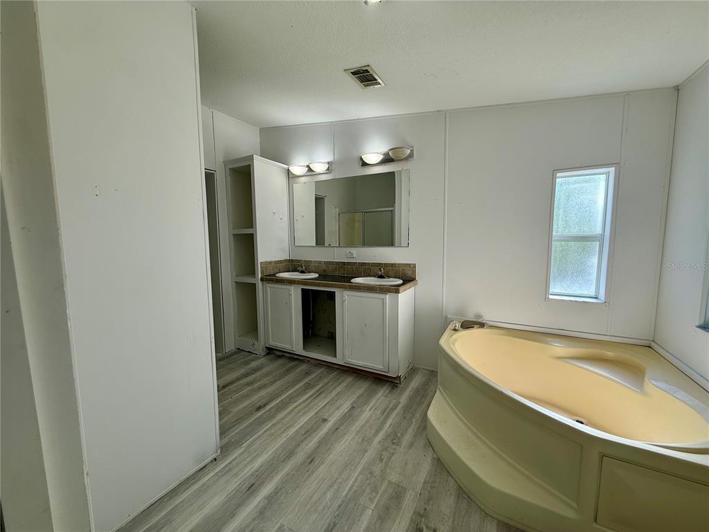 21471 Northwest 172nd Road High Springs, FL 32643 - Photo 13 of 26 a kitchen with stainless steel appliances a refrigerator a stove a sink and dishwasher with wooden floor