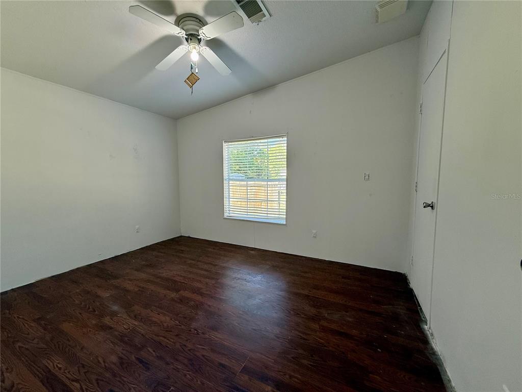 21471 Northwest 172nd Road High Springs, FL 32643 - Photo 15 of 26 an empty room with wooden floor chandelier fan and windows