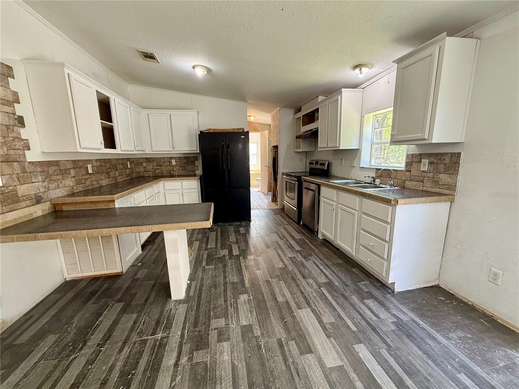 21471 Northwest 172nd Road High Springs, FL 32643 - Photo 5 of 26 a kitchen with kitchen island wooden floors appliances and sink