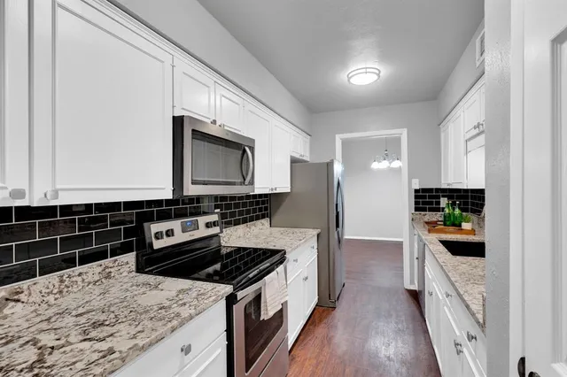 a kitchen with stainless steel appliances kitchen island granite countertop a stove a sink and a microwave