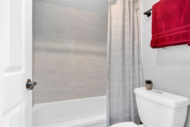 a bath room with a toilet and a bath tub