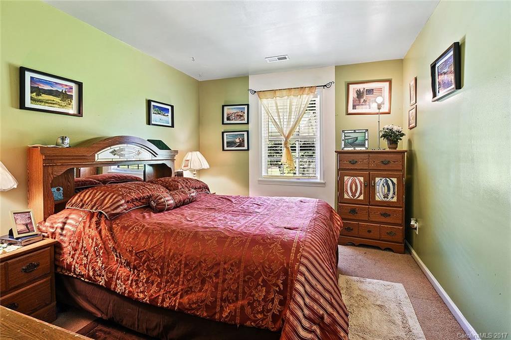 7101 Riding Trail Road, Unit 1 Charlotte, NC 28212 - Photo 11 of 14 a bed sitting in a bedroom next to a window