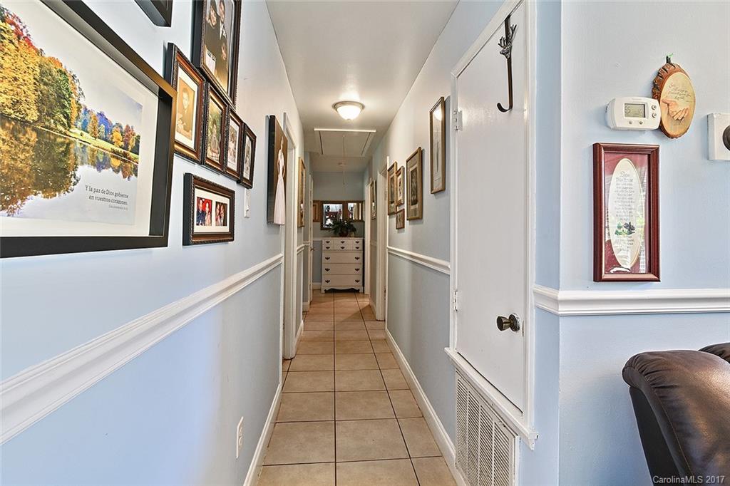 7101 Riding Trail Road, Unit 1 Charlotte, NC 28212 - Photo 5 of 14 a hallway with couches a dining table and chairs