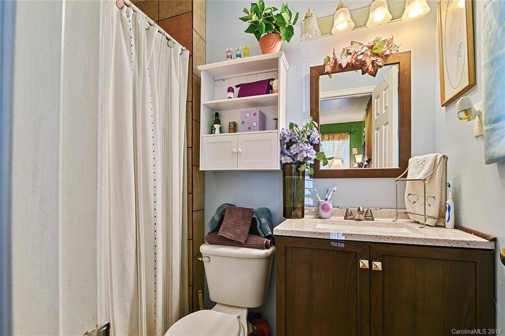 7101 Riding Trail Road, Unit 1 Charlotte, NC 28212 - Photo 10 of 14 a bathroom with a sink a toilet and a mirror