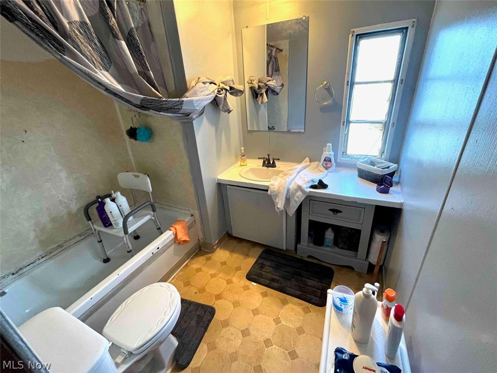 403 Lee Road Follansbee, WV 26037 - Photo 36 of 37 Bathroom featuring a tub/shower combination, hexagon-patterned flooring, single vanity with integrated sink, and an elongated window
