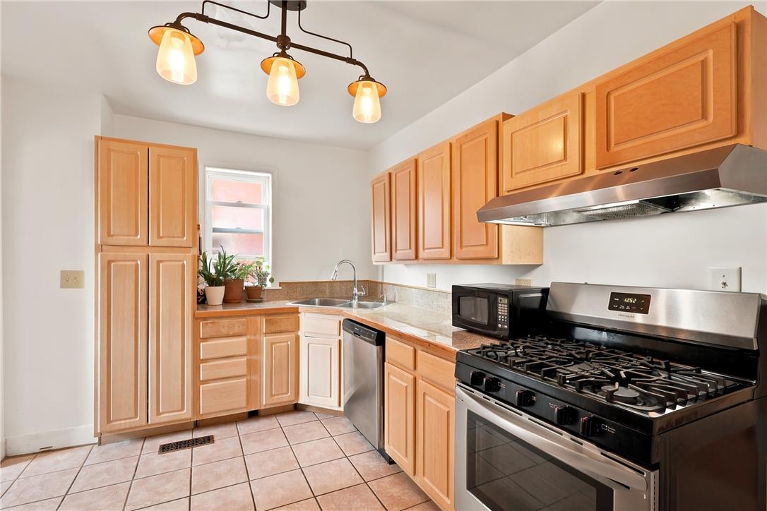 803 Spring Street Bethlehem, PA 18018 - Photo 11 of 34 A well-equipped kitchen features honey-toned cabinetry and essential appliances.