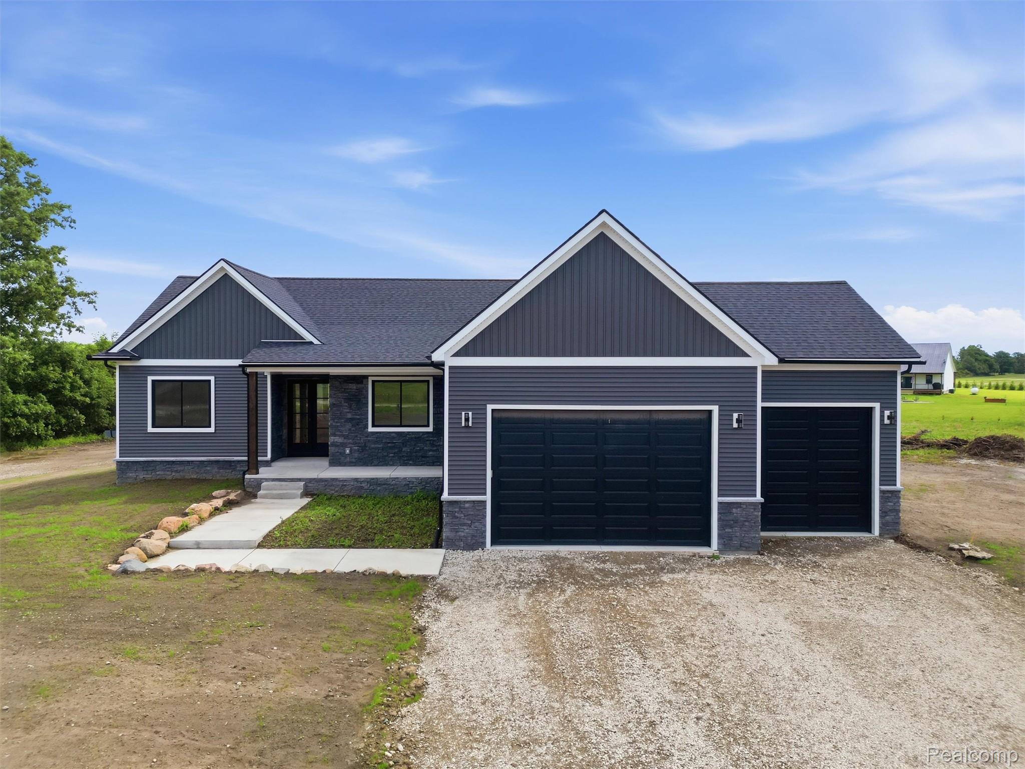 Contemporary ranch-style residence featuring dark gray horizontal siding and vertical accents