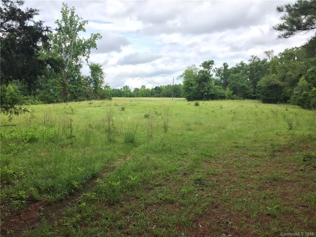 a view of a green field with wooden fence