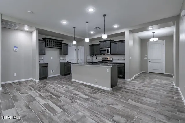 a view of kitchen with kitchen island a sink stainless steel appliances and cabinets