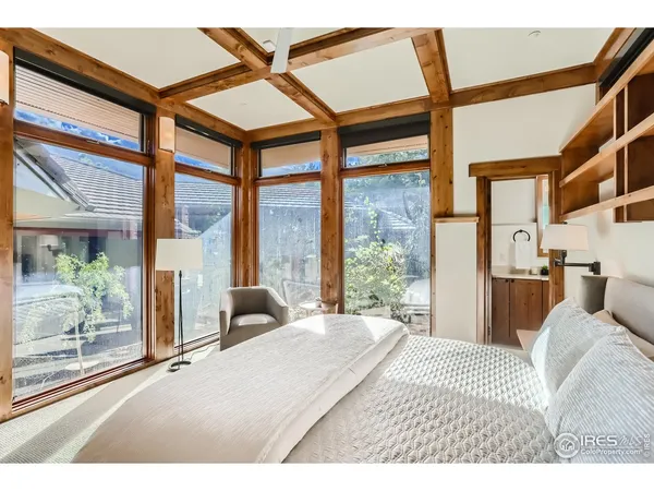a bedroom with a bed and a large window with balcony view