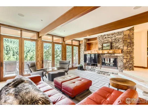 a dining hall with couches a flat tv screen and couches with wooden floor