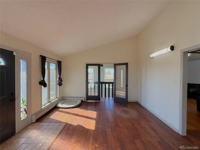 a view of empty room with wooden floor