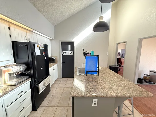 a kitchen with stainless steel appliances granite countertop a refrigerator a stove and a sink