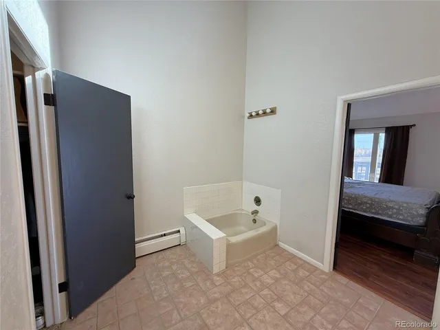 a bathroom with a tub a sink and a mirror