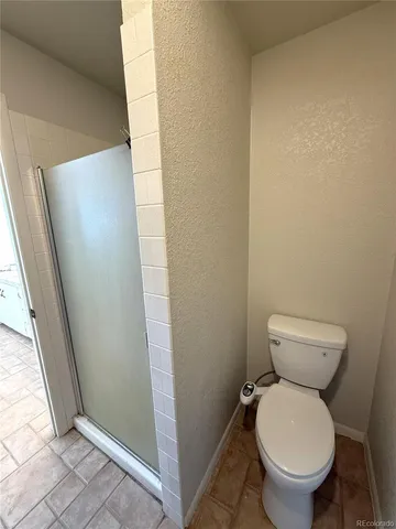 a bathroom with a toilet and a shower