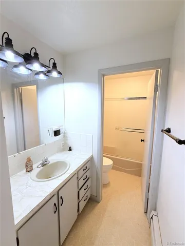 a bathroom with a granite countertop sink mirror and a bathtub