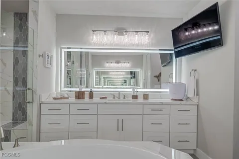 a bathroom with a sink a large mirror and a window