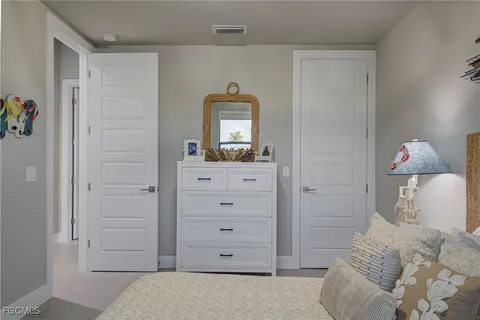 a bedroom with a bed and a dresser in it