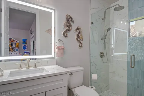 a bathroom with a sink vanity mirror and toilet