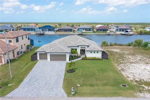 an aerial view of a house with a garden and lake view
