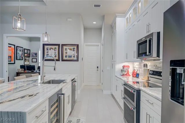 a kitchen that has a lot of cabinets in it and wooden floors