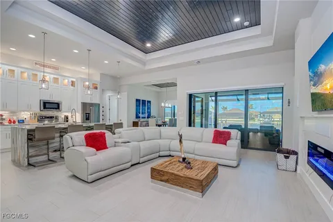 a living room with furniture kitchen view and a large window