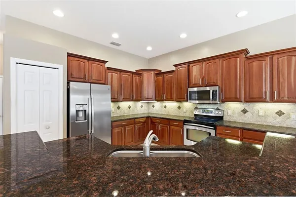 a kitchen with stainless steel appliances a refrigerator and a stove