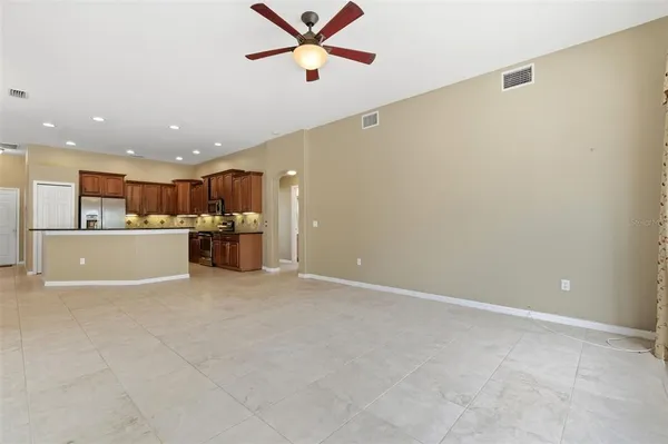 a view of a livingroom with a ceiling fan & hallway