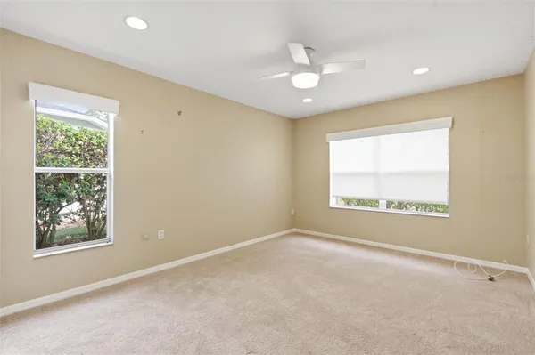 an empty room with a ceiling fan and a window